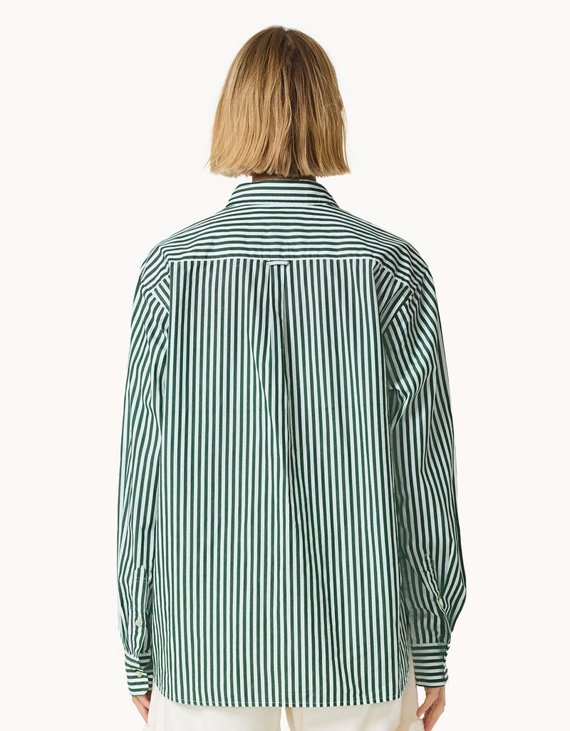 Back view of a person wearing a green and white striped shirt on a light gray background