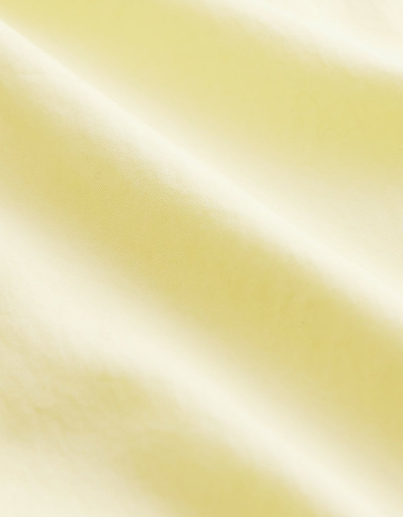 Close-up of light yellow fabric with folds