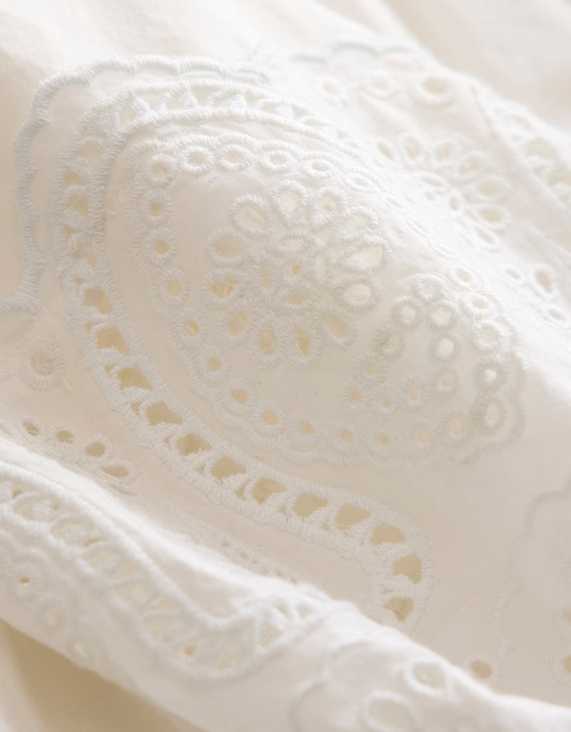 Close-up of white poplin fabric with intricate embroidery detailing
