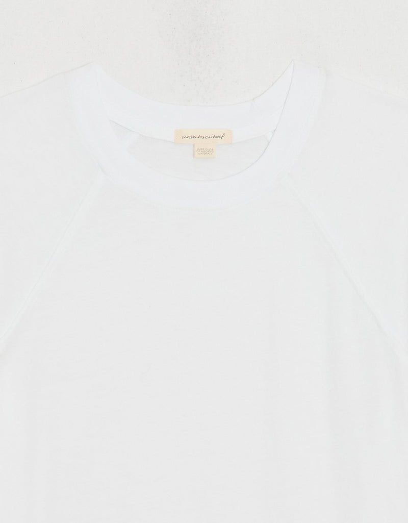 Close-up of a white t-shirt with exposed unsubscribed brand tag on a white background