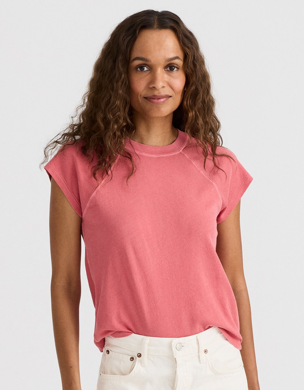 Woman wearing a brick red raglan t-shirt against a light gray background