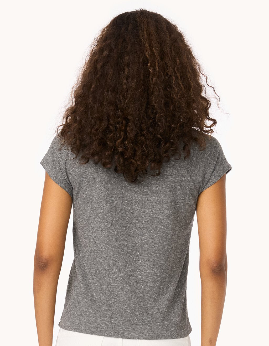 Back view of a woman wearing a heather gray raglan t-shirt on a white background