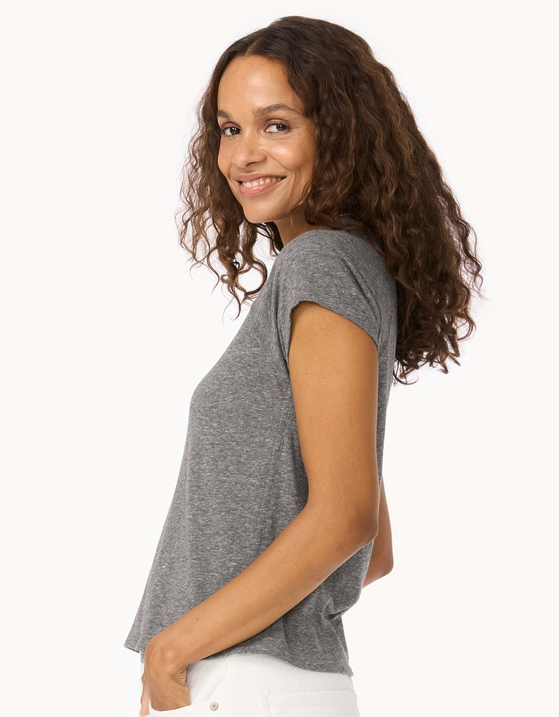 Side view of a woman wearing a heather gray raglan t-shirt on a white background