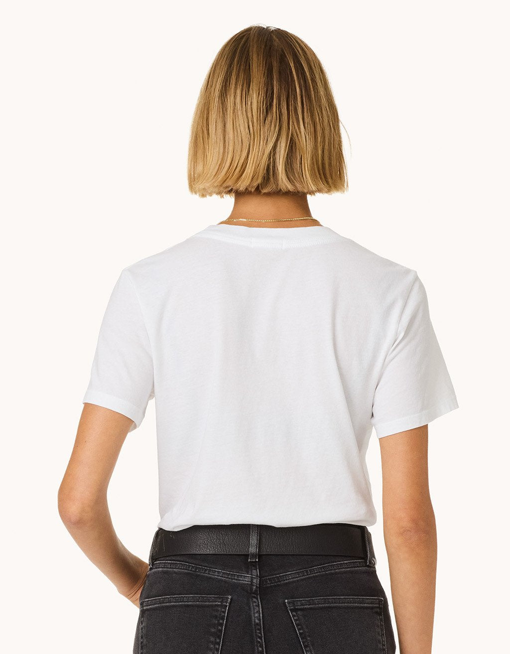 Back view of a person wearing a white t-shirt and black pants on a white background