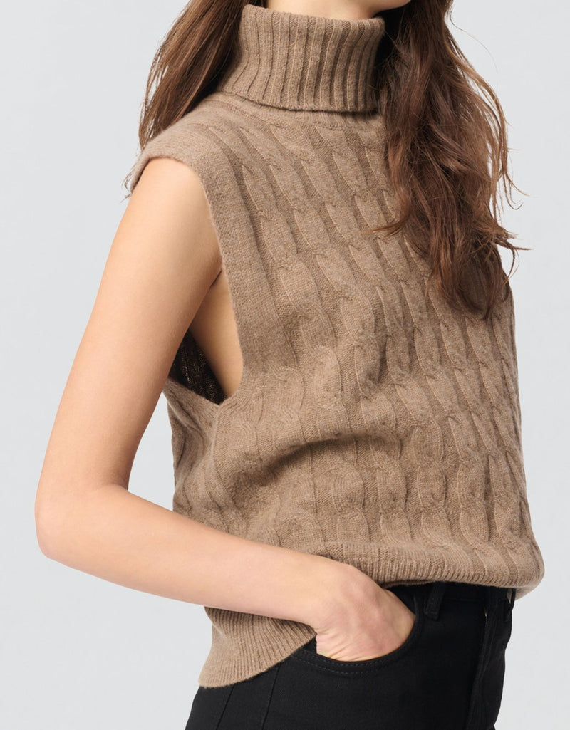 Camel knit sleeveless turtleneck sweater worn by a woman on a light gray background