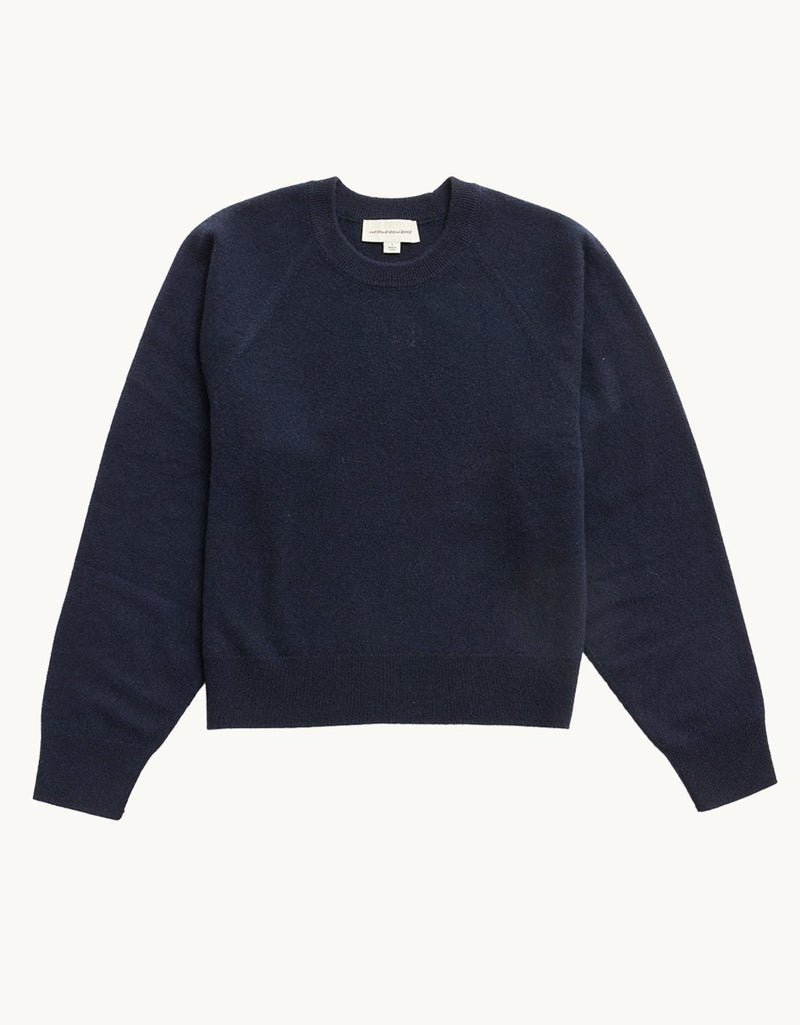 Navy cashmere raglan sweater on a light gray background