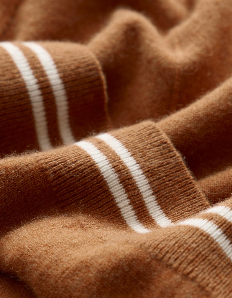 Close-up of burnt orange cashmere fabric with white stripe accents
