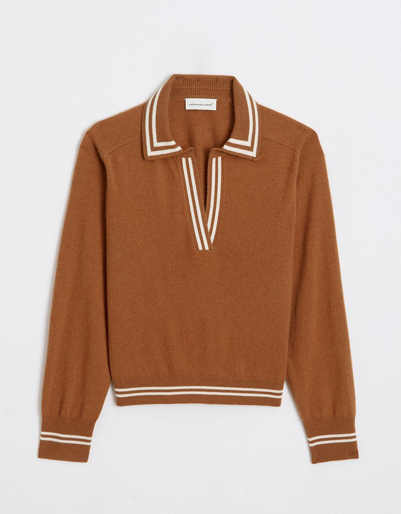Burnt orange cashmere polo sweater with white trim on a light gray background