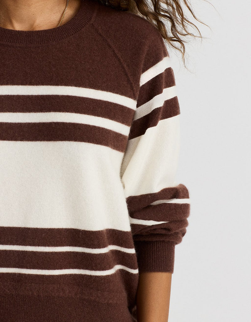 Close-up of a brown and white striped cashmere sweater on a light gray background