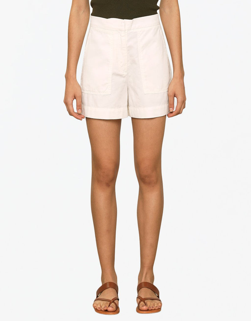 Person wearing ivory shorts on a plain background