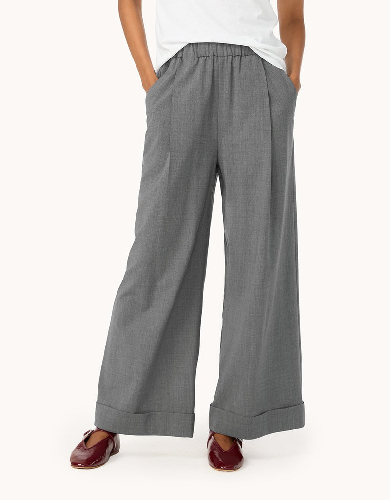 Person wearing gray wide-leg pants on a light gray background