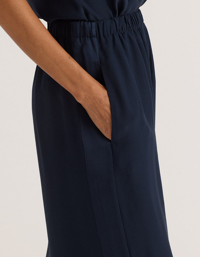 Navy blue wide leg pants worn by a person on a plain background