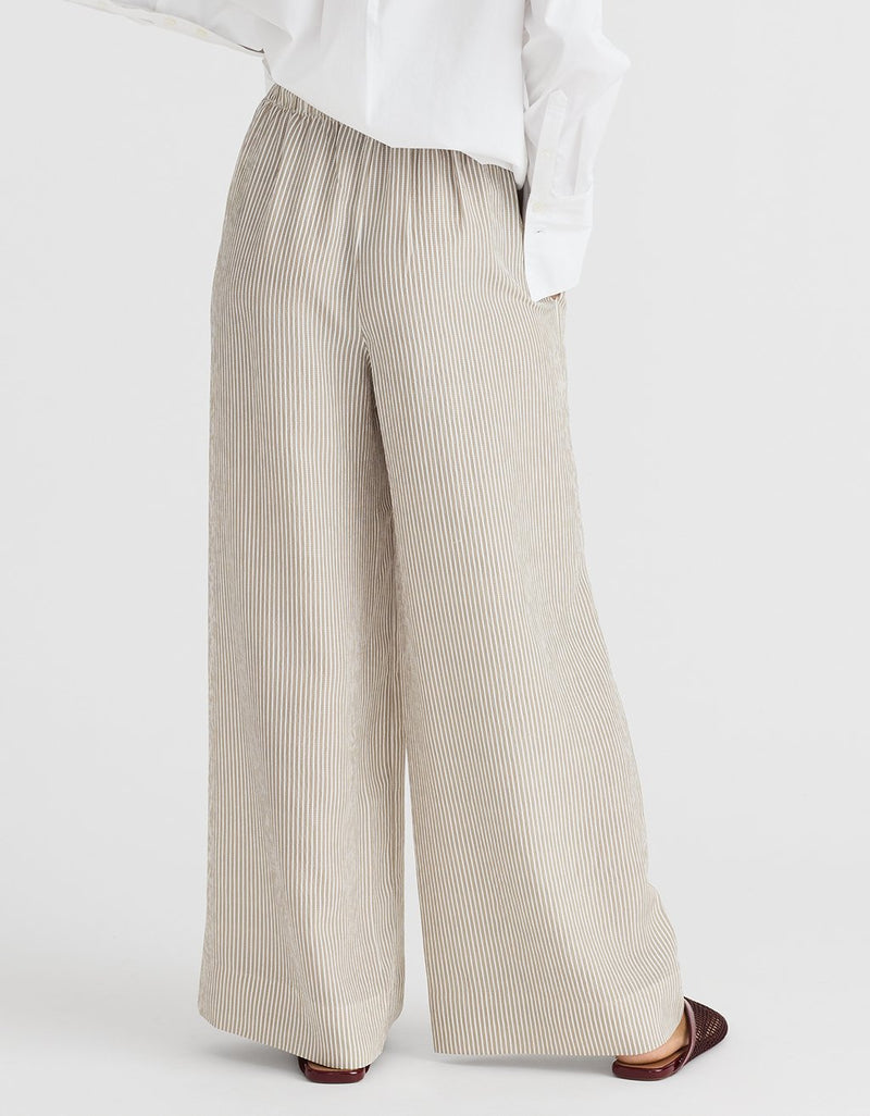 Stripe beige wide-leg pants worn with a white shirt on a white background