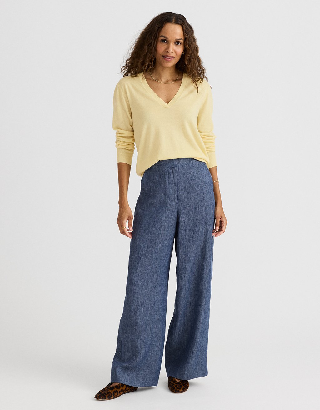 Woman wearing a yellow sweater and blue hemp wide-leg pants on a white background