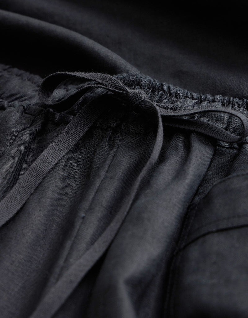 Close-up of elastic waistband with tie detail on black pants