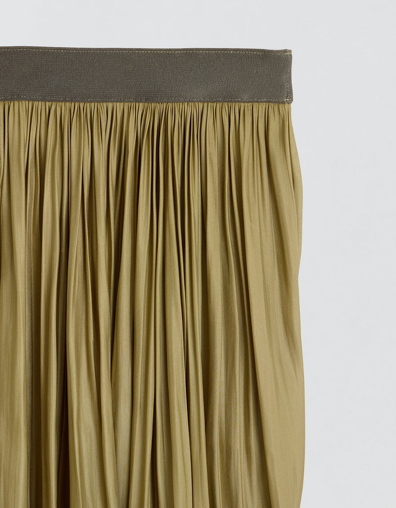Close-up of an olive pleated skirt with elastic waistband on a light gray background