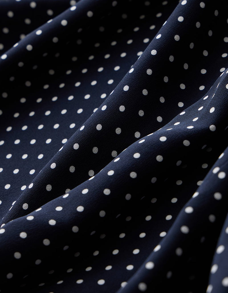 Close-up of a navy blue fabric with white polka dots