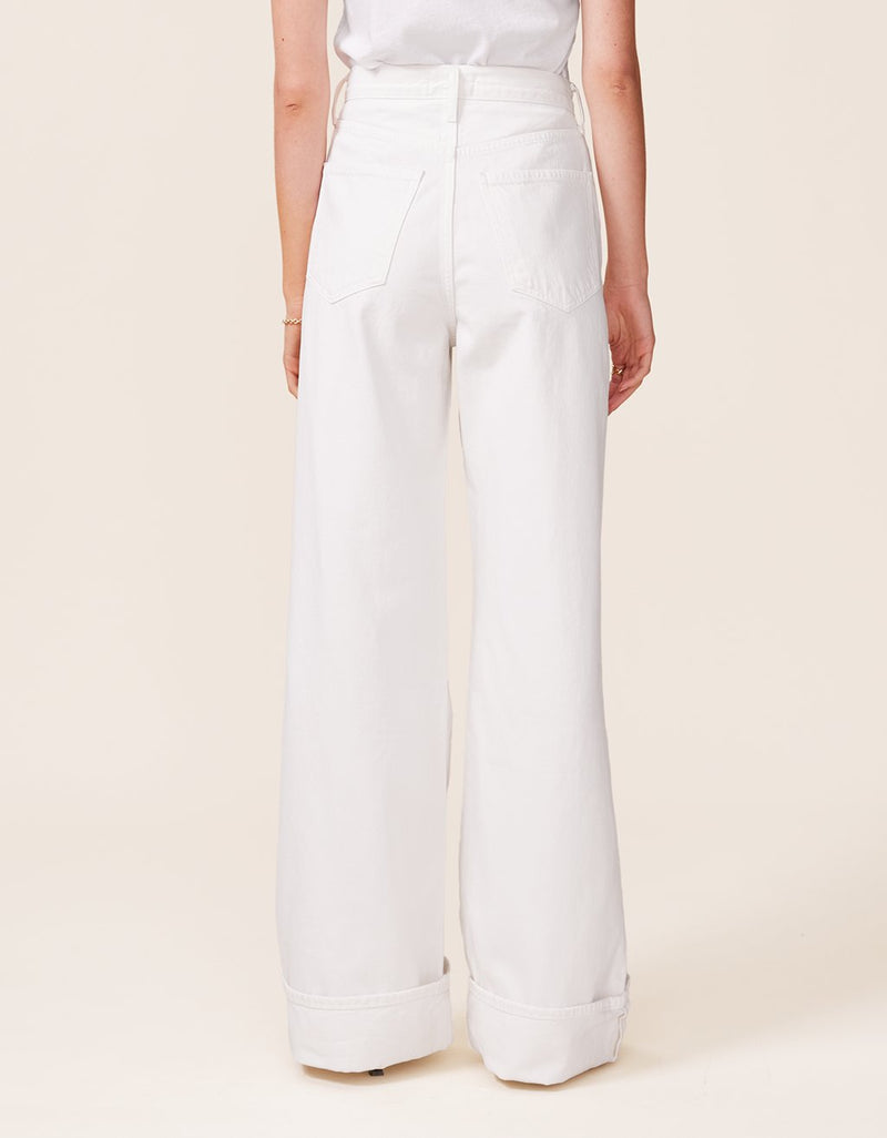 White wide-leg jeans worn by a person on a beige background