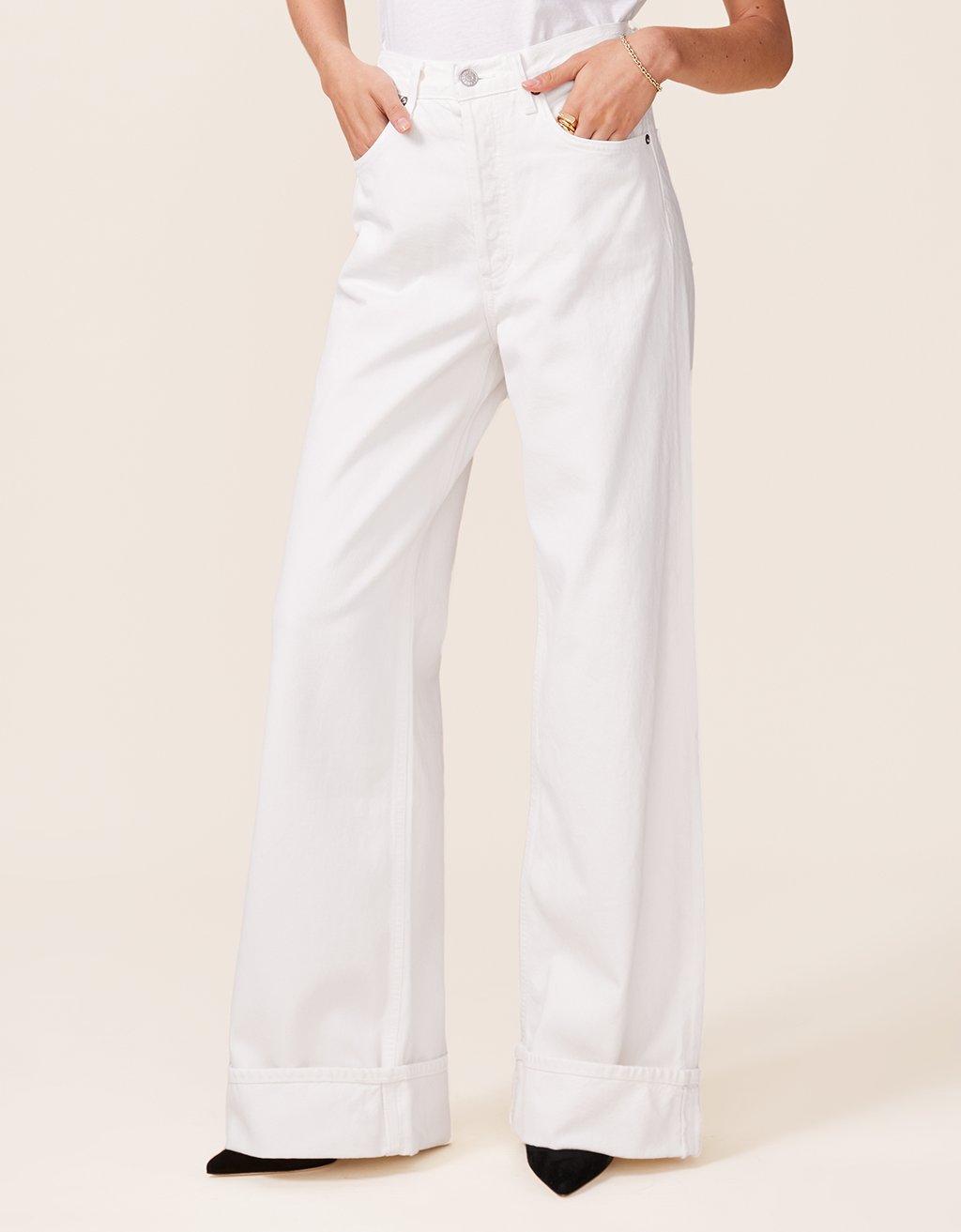 White wide-leg jeans worn by a person on a plain background