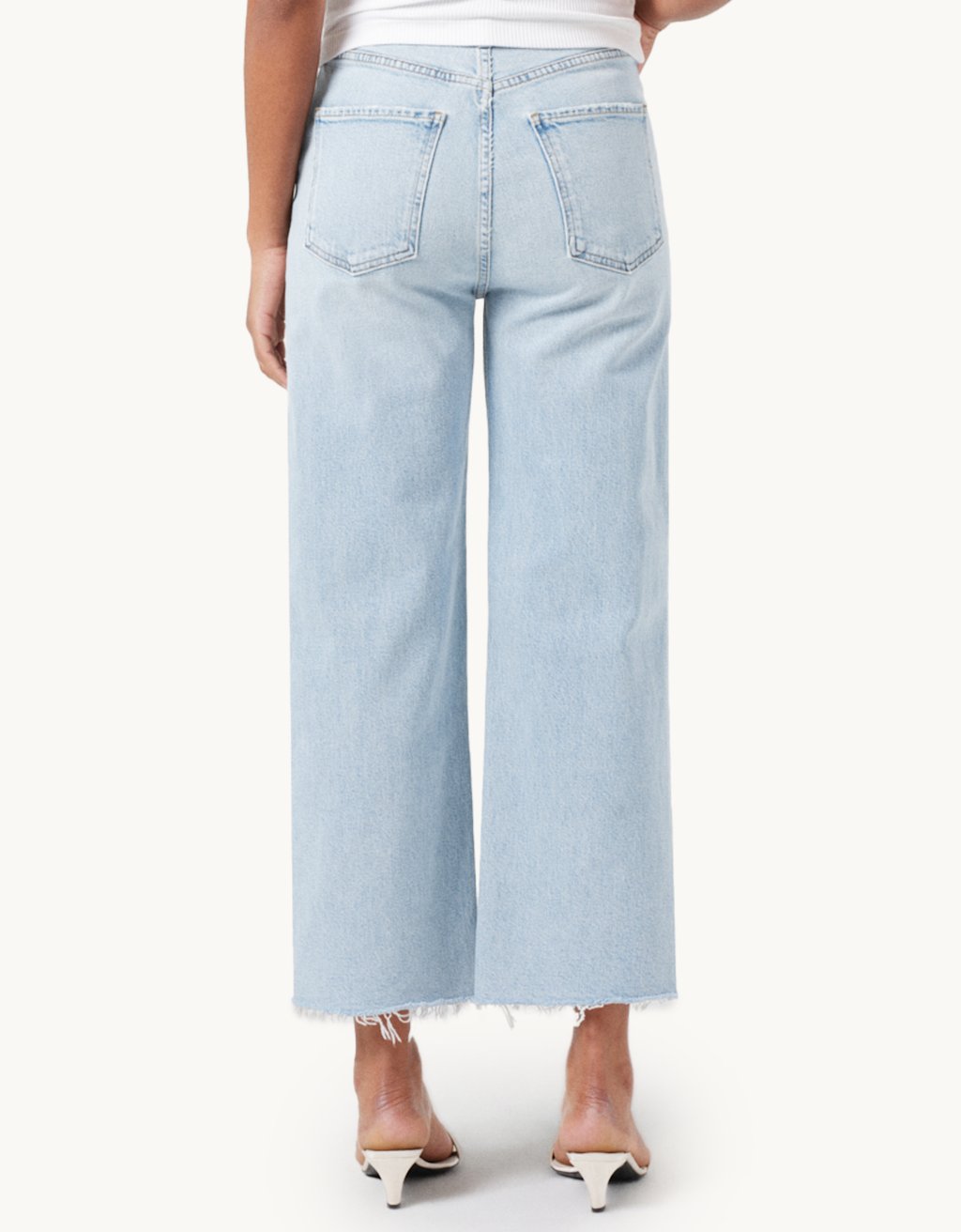 Light blue high-rise, wide-leg jeans worn by a person on a white background