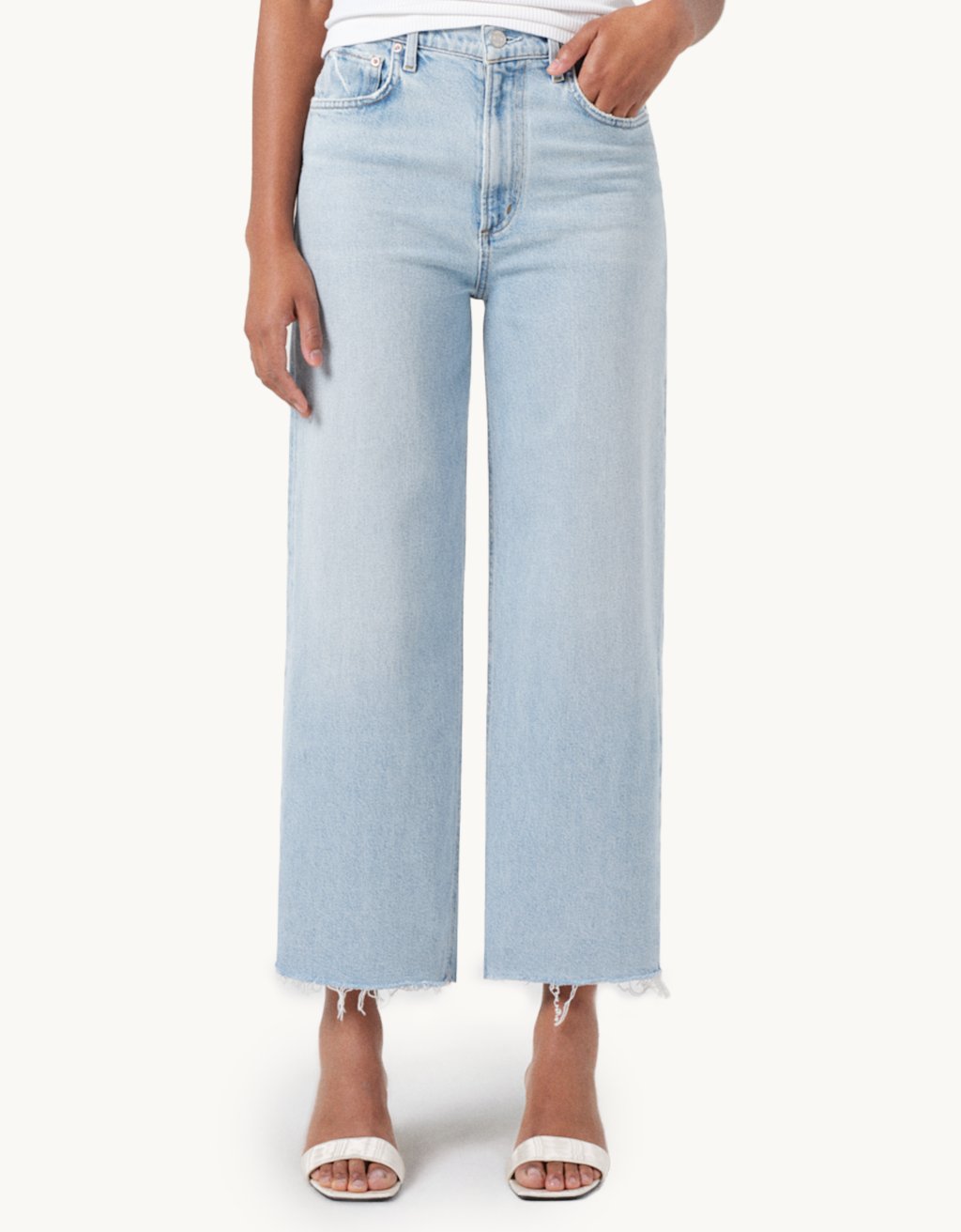 Light blue high-rise, wide-leg jeans worn by a person on a white background