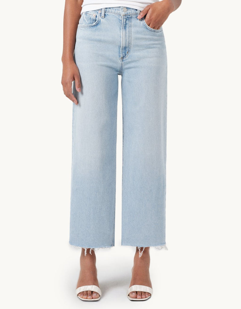 Light blue high-rise, wide-leg jeans worn by a person on a white background