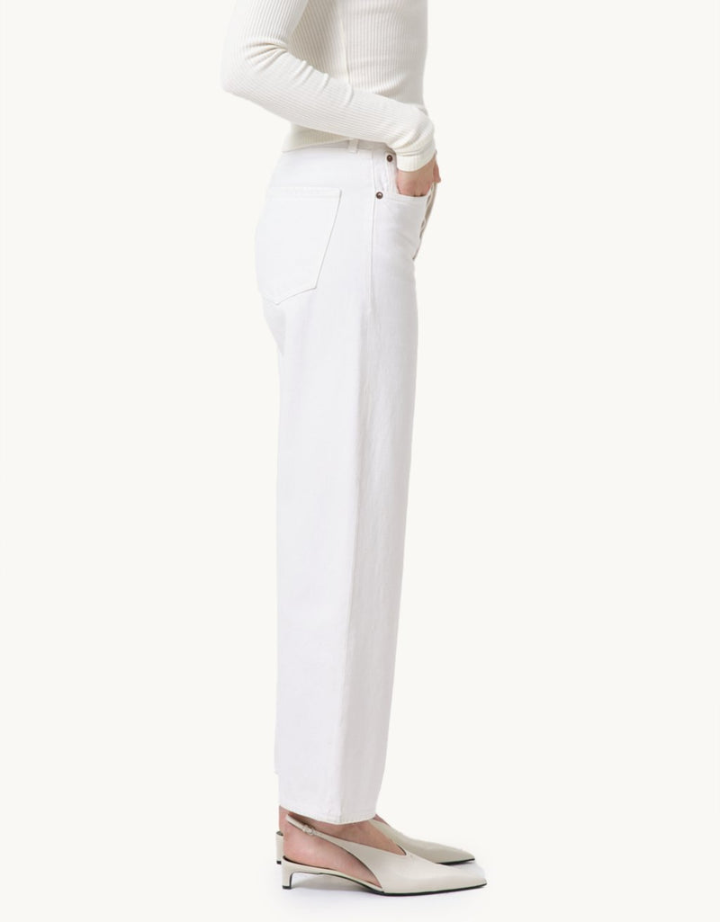 Ivory high-rise jeans and a cream top worn by a person on a neutral background