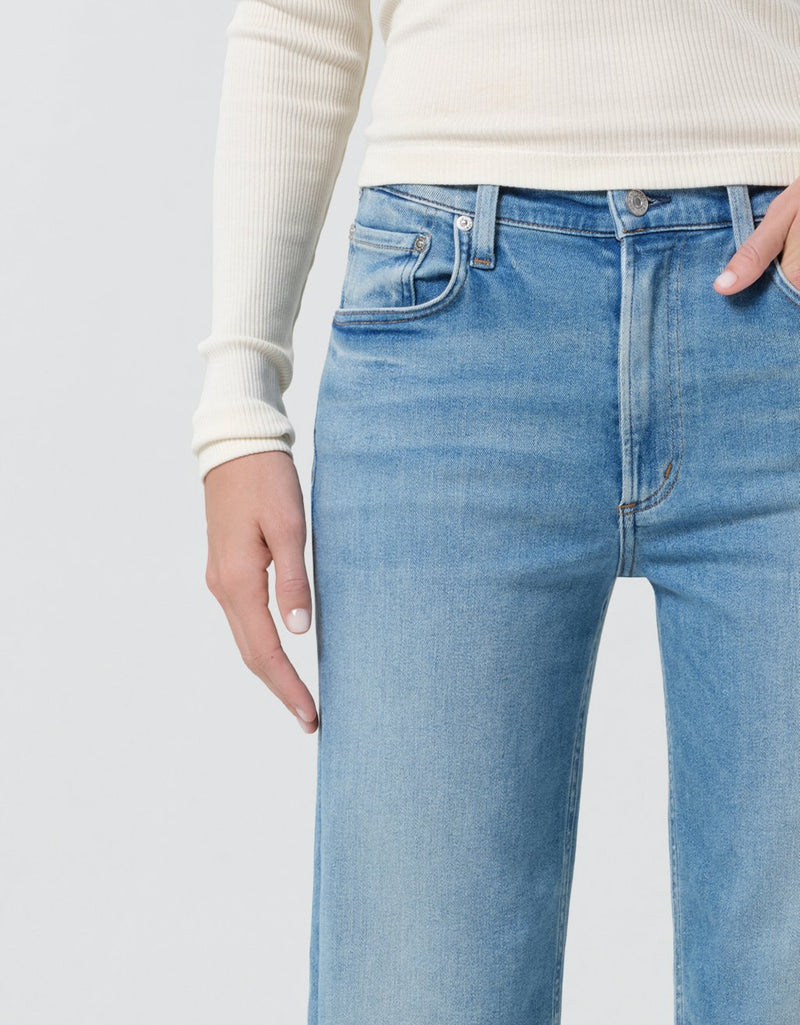 Light blue jeans worn by a person on a plain background