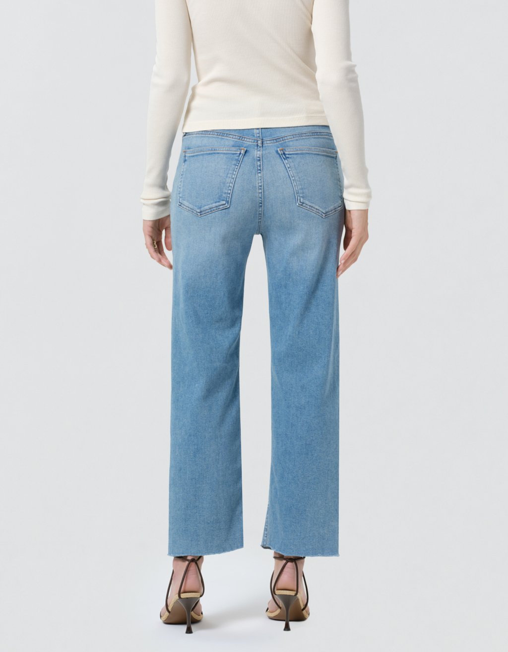 Light blue jeans worn by a person on a white background