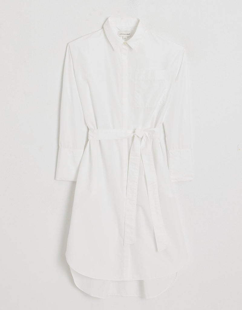 Belted white shirtdress on a light gray background