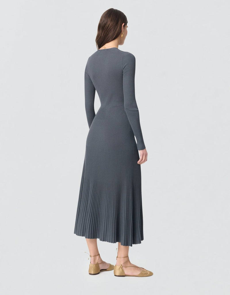 Woman wearing a gray ribbed long sleeve dress on a light gray background