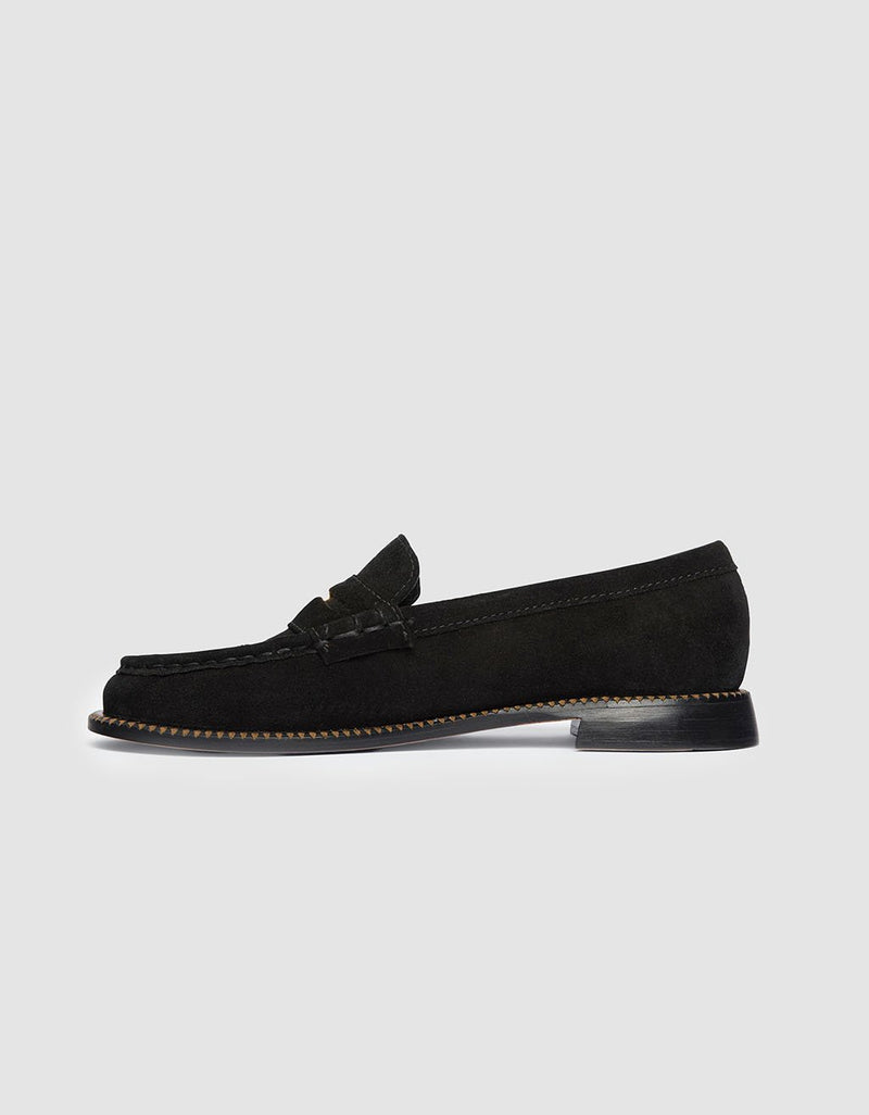 Side view of a black suede loafer shoe on a light gray background