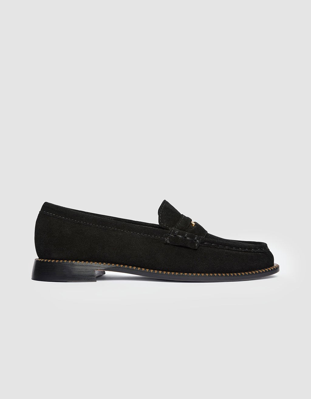 Side view of a black suede loafer shoe on a light gray background