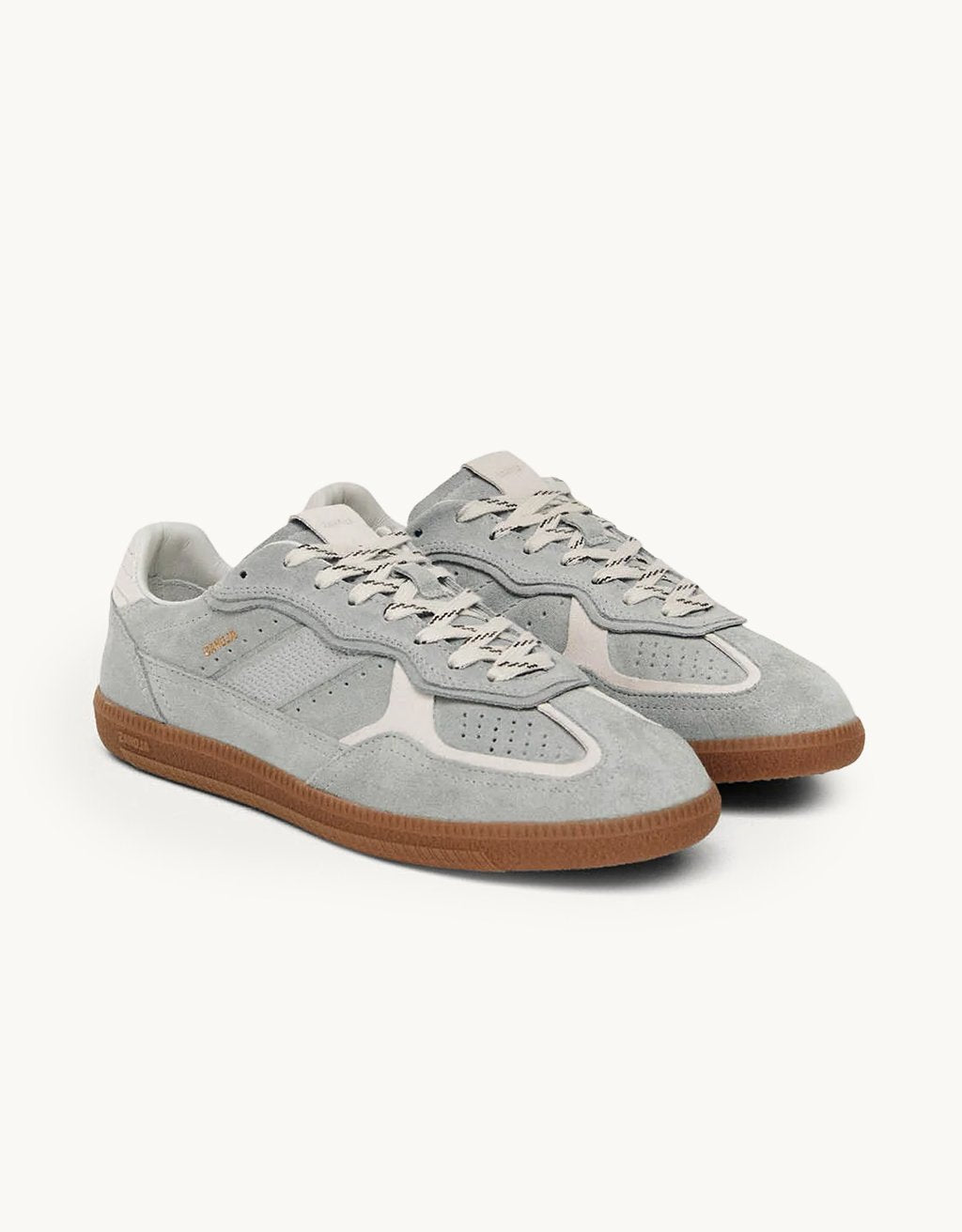Gray leather low top sneakers with white details and rubber soles on a light gray background