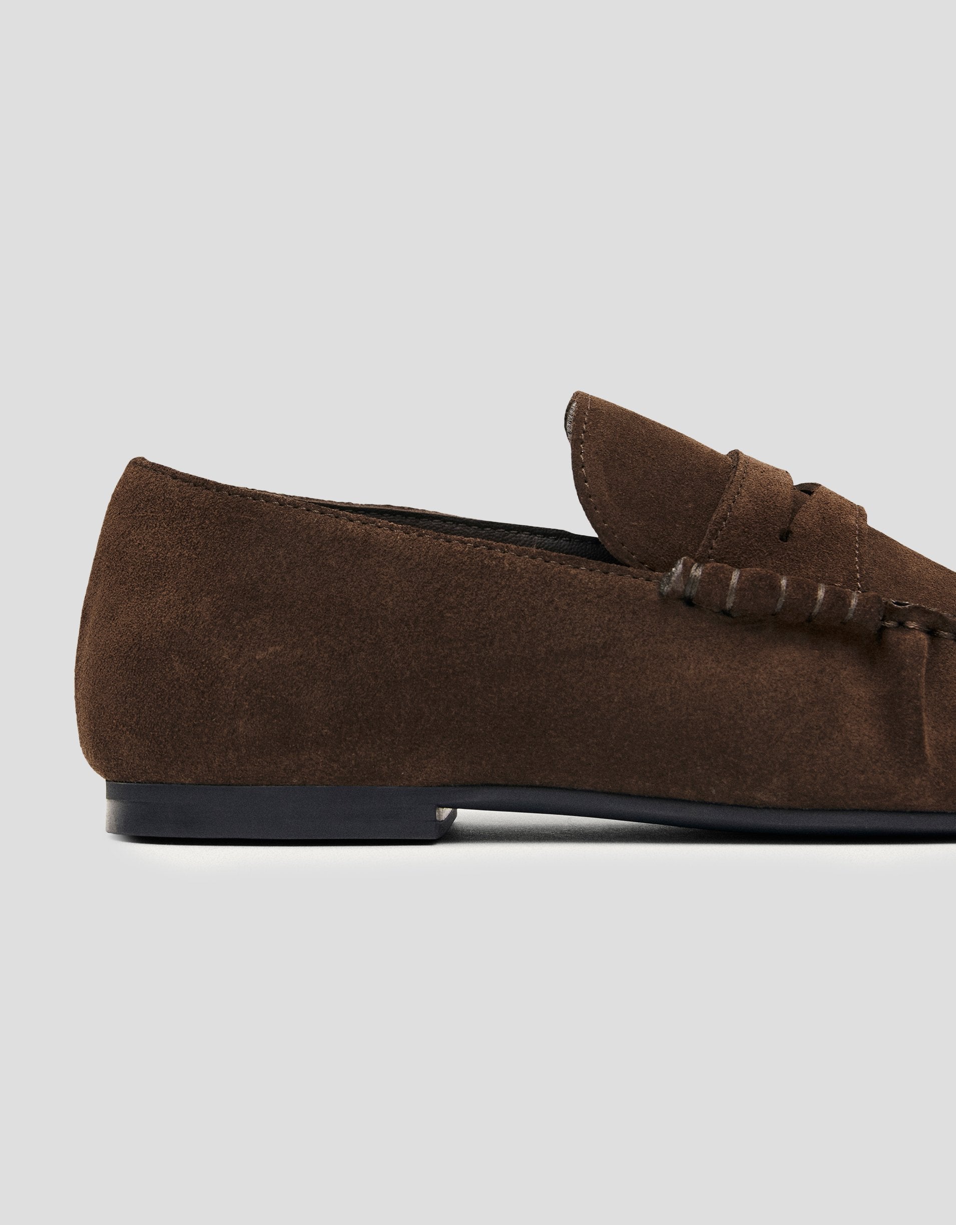 Brown suede loafer on a light gray background