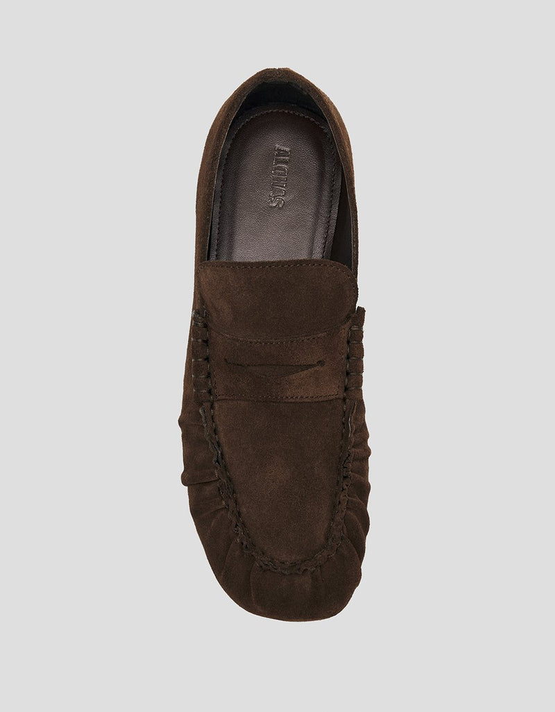 Brown suede loafer shoe on a light gray background