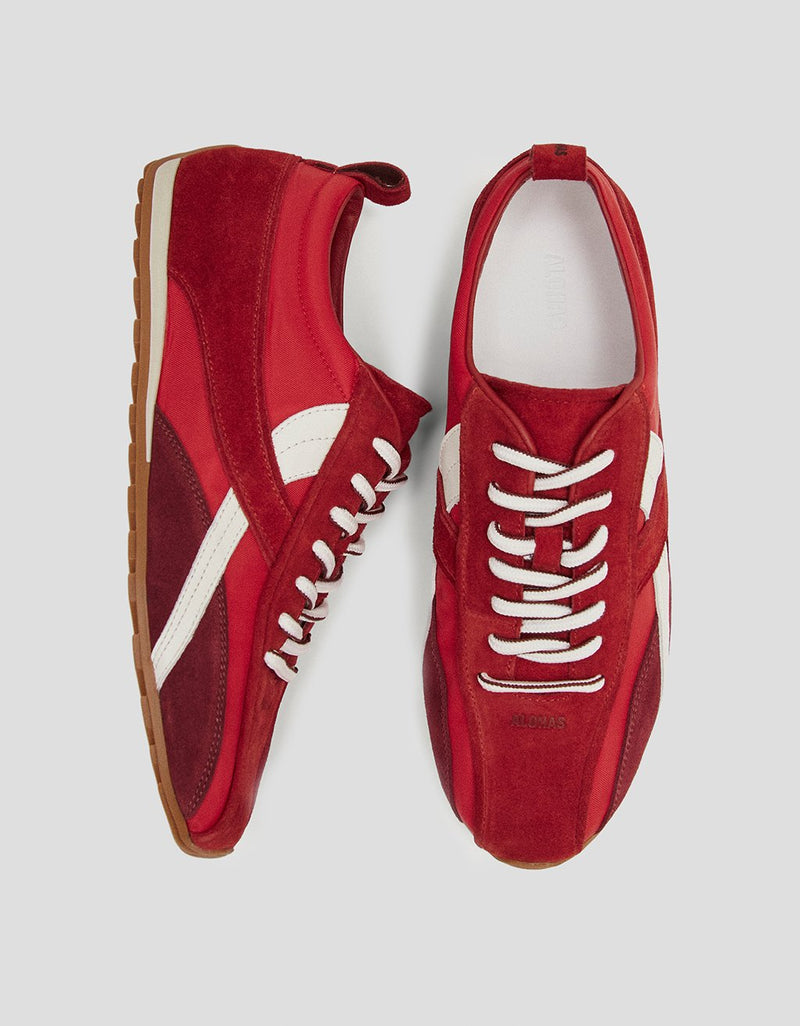 Top and side view of red leather sneakers with white laces on a light gray background