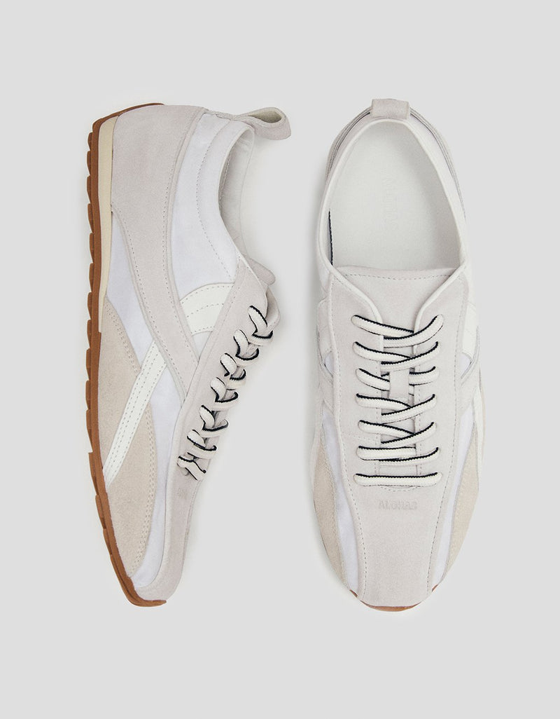 Top and side views of a pair of white leather sneakers on a light gray background