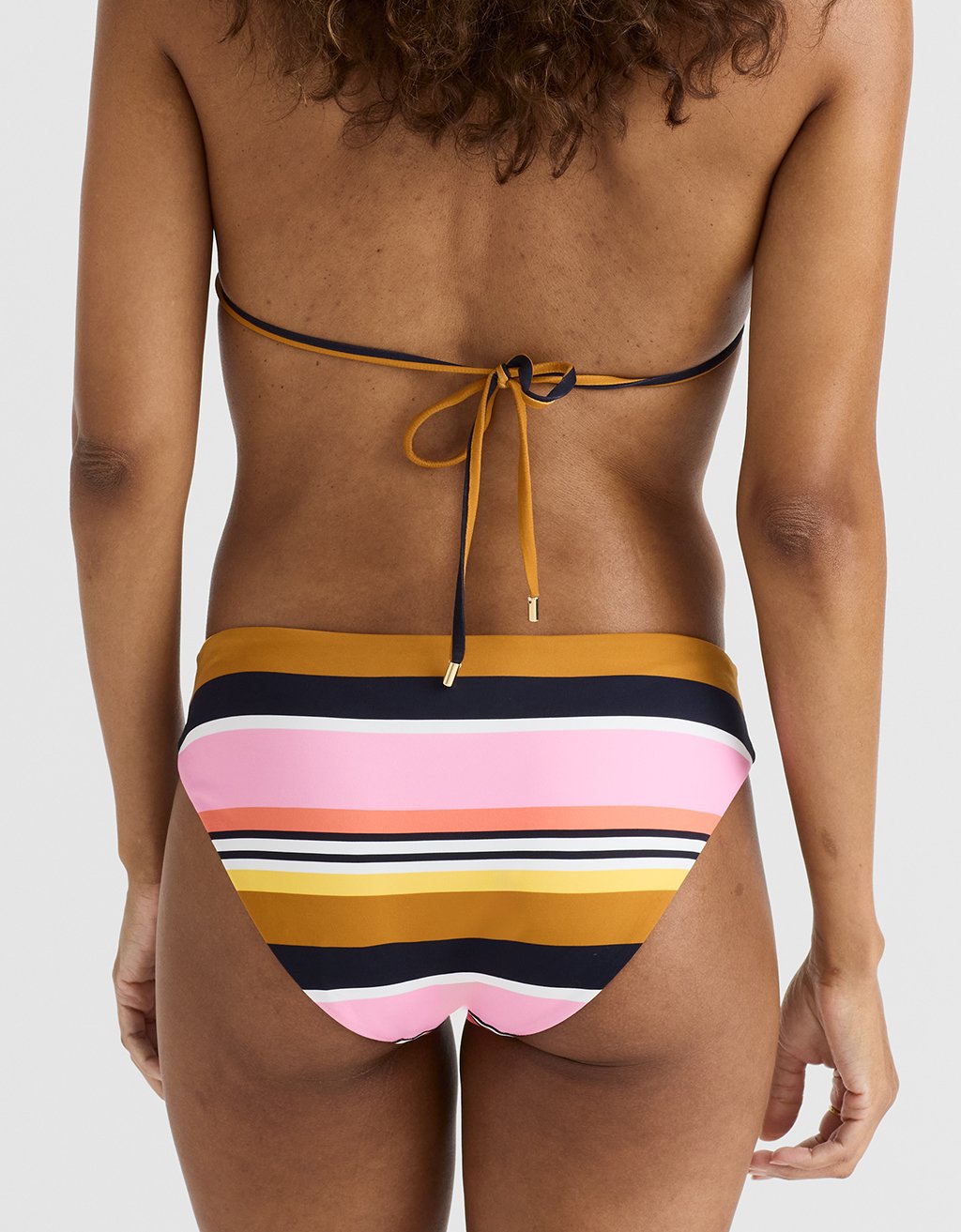 Multicolored striped bikini bottom on a plain background