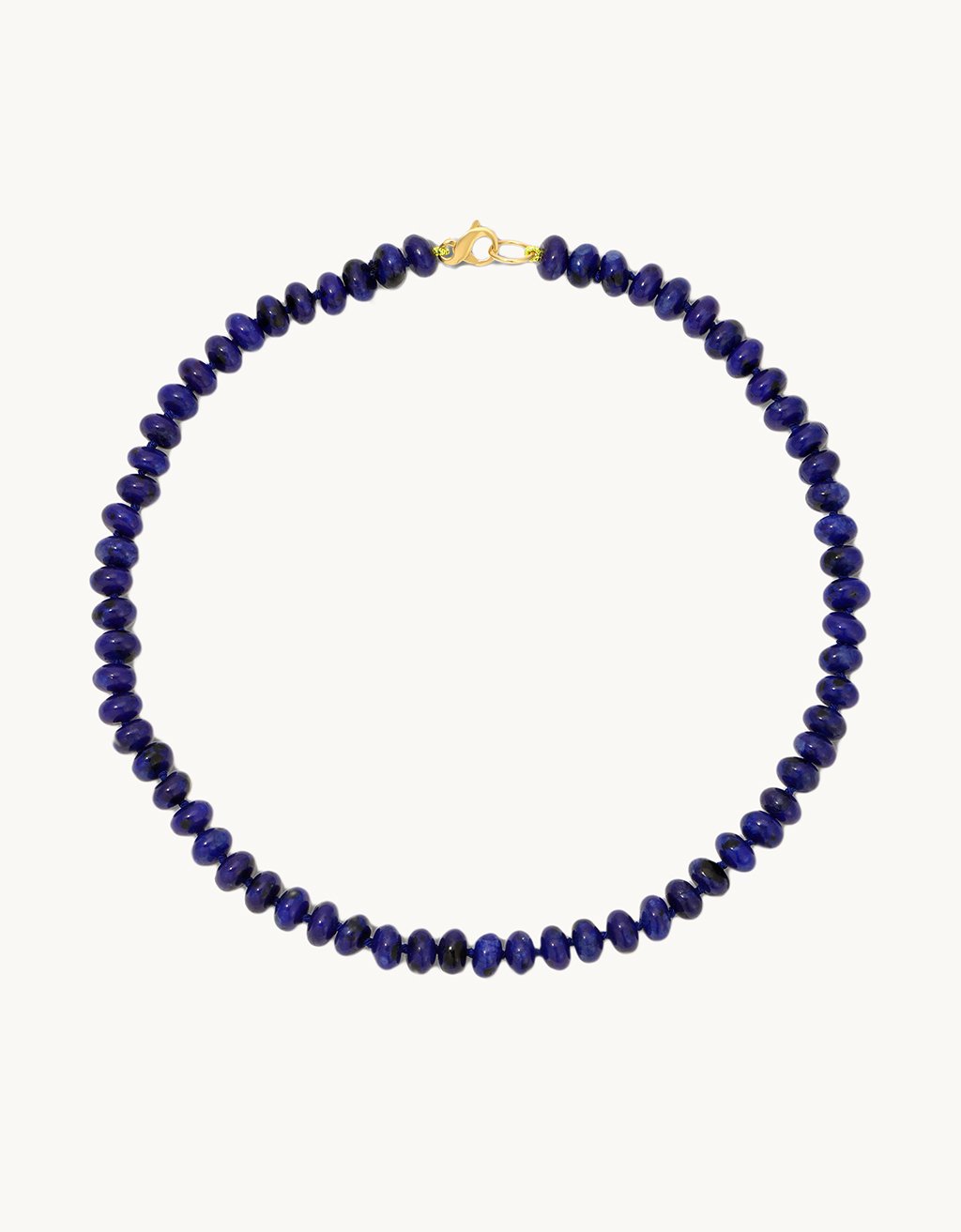 Necklace with blue beads and lobster clasp closure on a light gray background