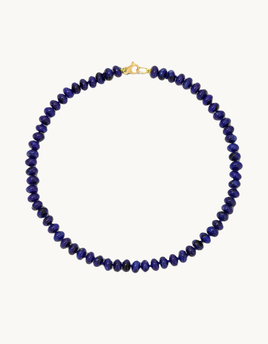 Necklace with blue beads and lobster clasp closure on a light gray background