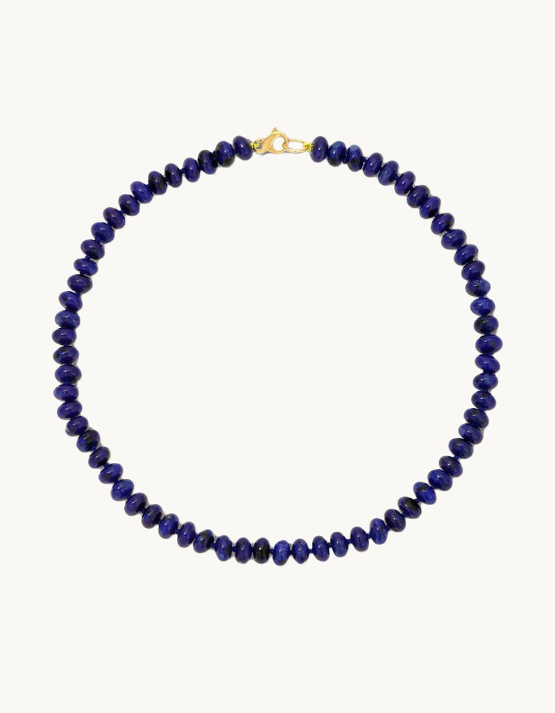 Necklace with blue beads and lobster clasp closure on a light gray background