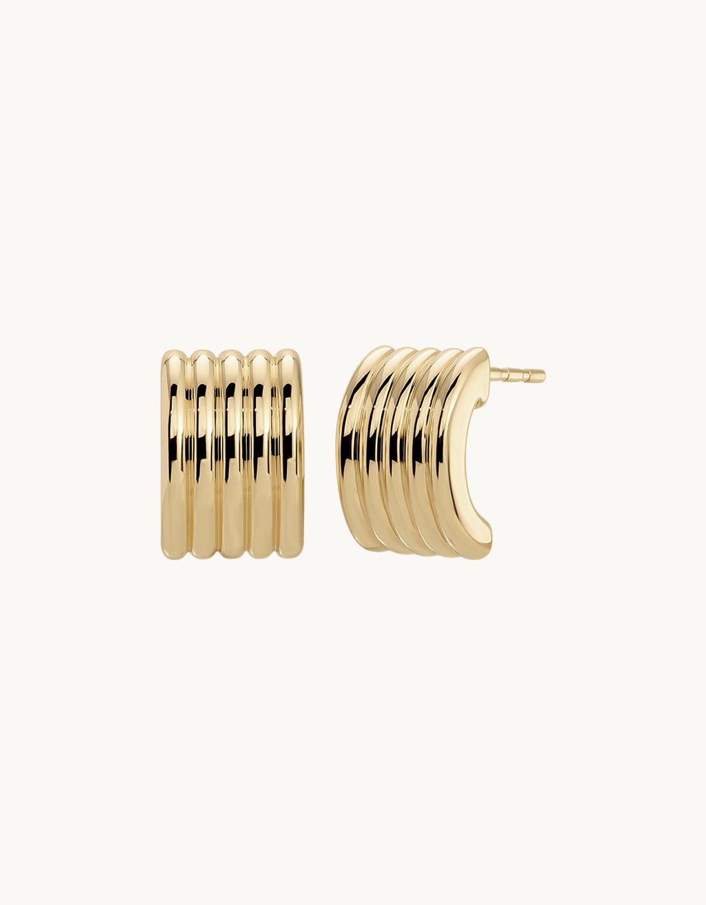 Gold fluted stud earrings on a light gray background