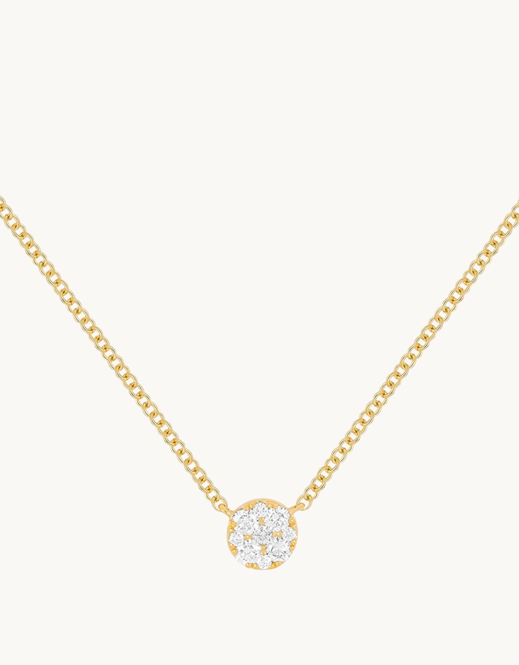 Close-up of a round diamond pendant on a 14k yellow gold chain against a light gray background