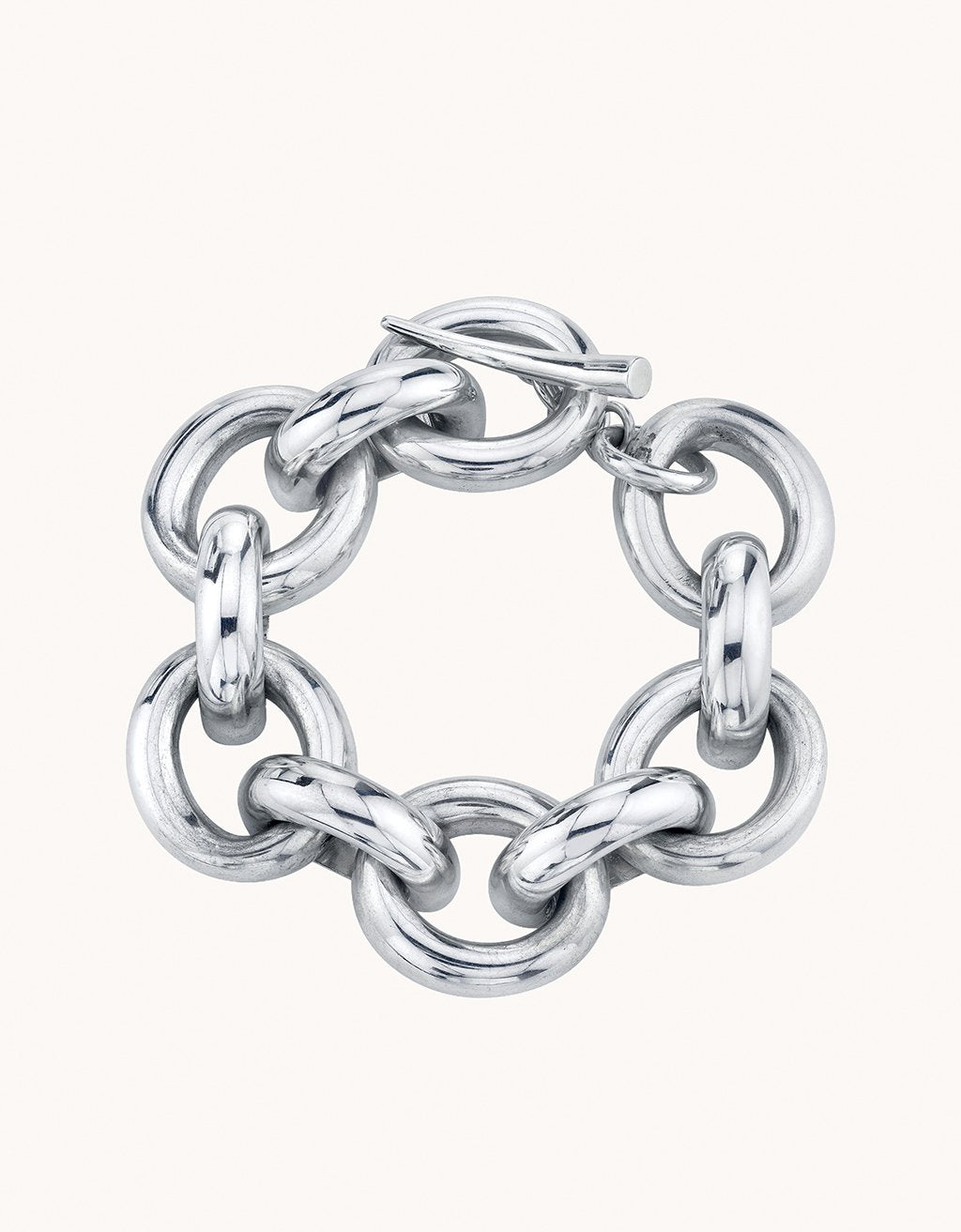 Chunky silver chain link bracelet on a plain background