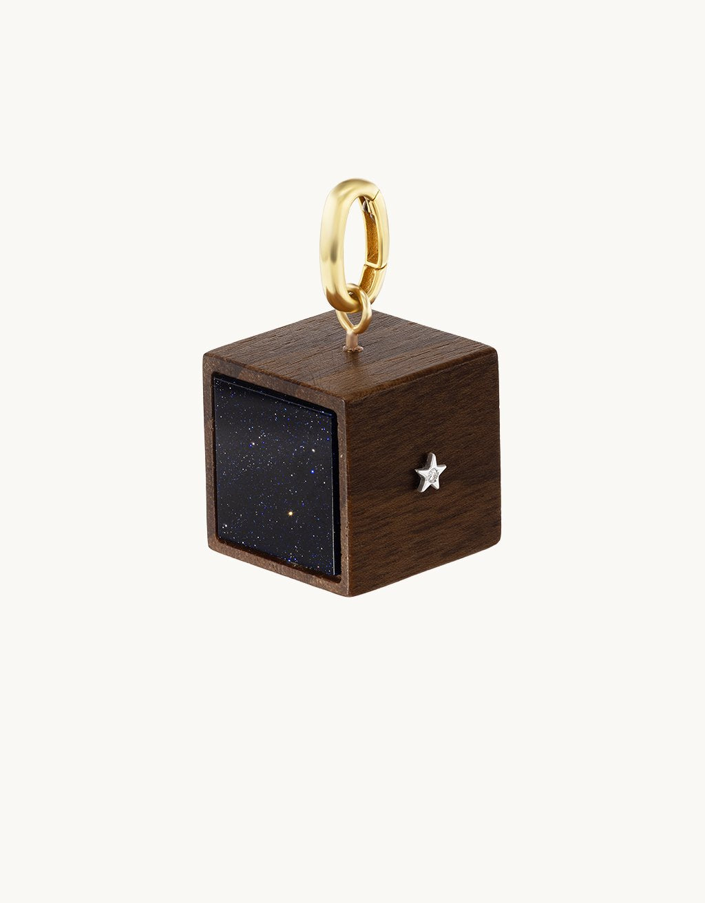 Wooden cube pendant with gold ring and star charm on a light gray background