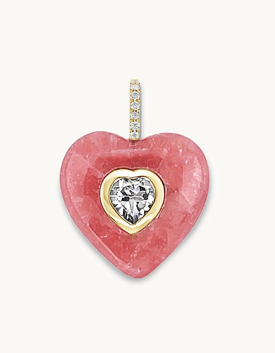 Heart-shaped pendant carved from genuine Pink Rhodochrosite gemstone with a crystal quartz center stone and diamond bail on a light gray background