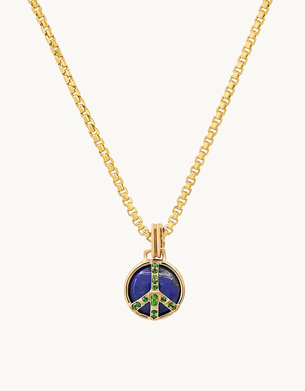 Peace sign pendant featuring blue and green stones on a gold chain and a light gray background