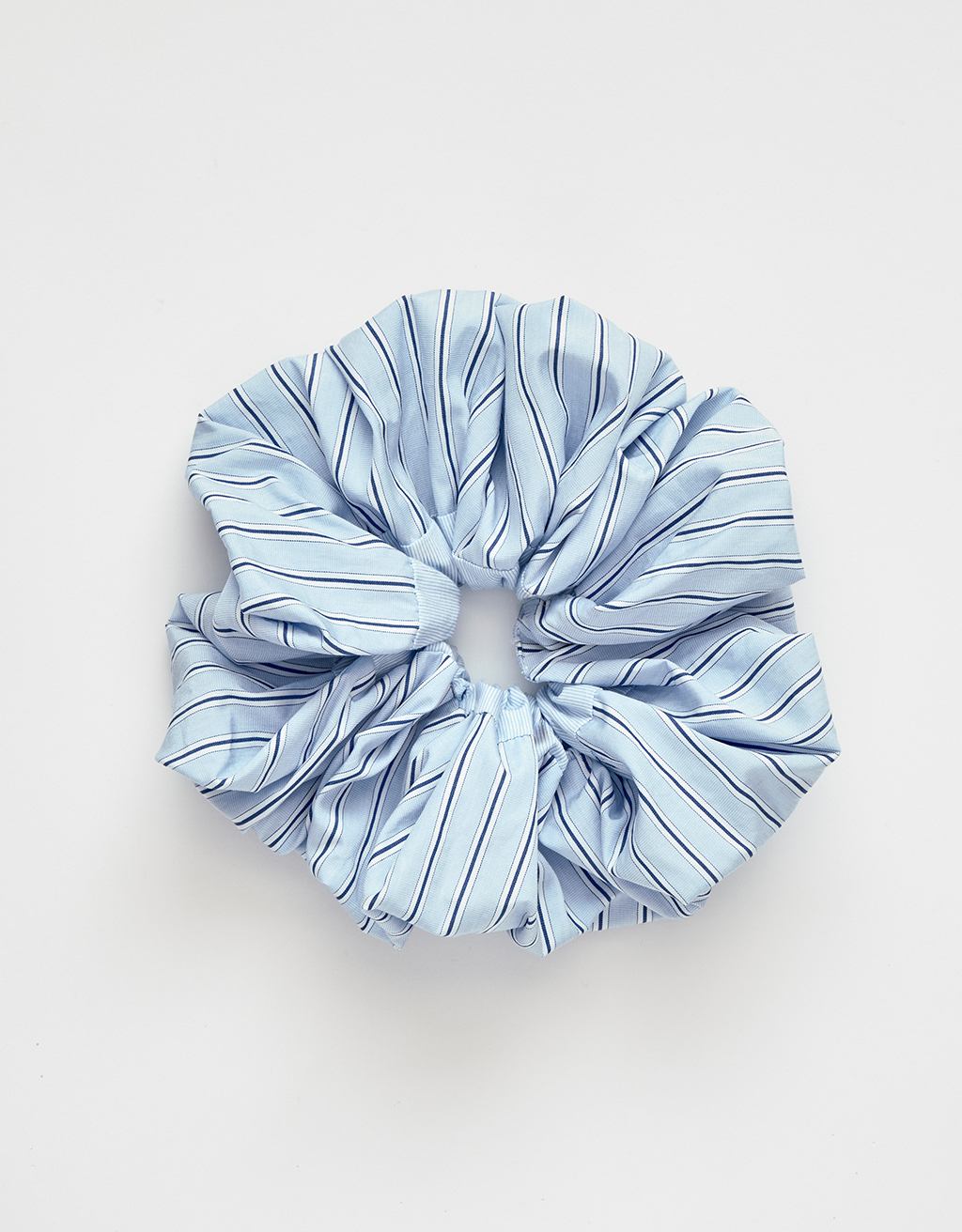 Blue striped poplin scrunchie on a light gray background
